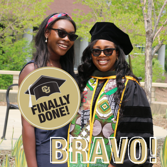 2 ladies wearing cap and gown with a CU Anschutz sticker.
