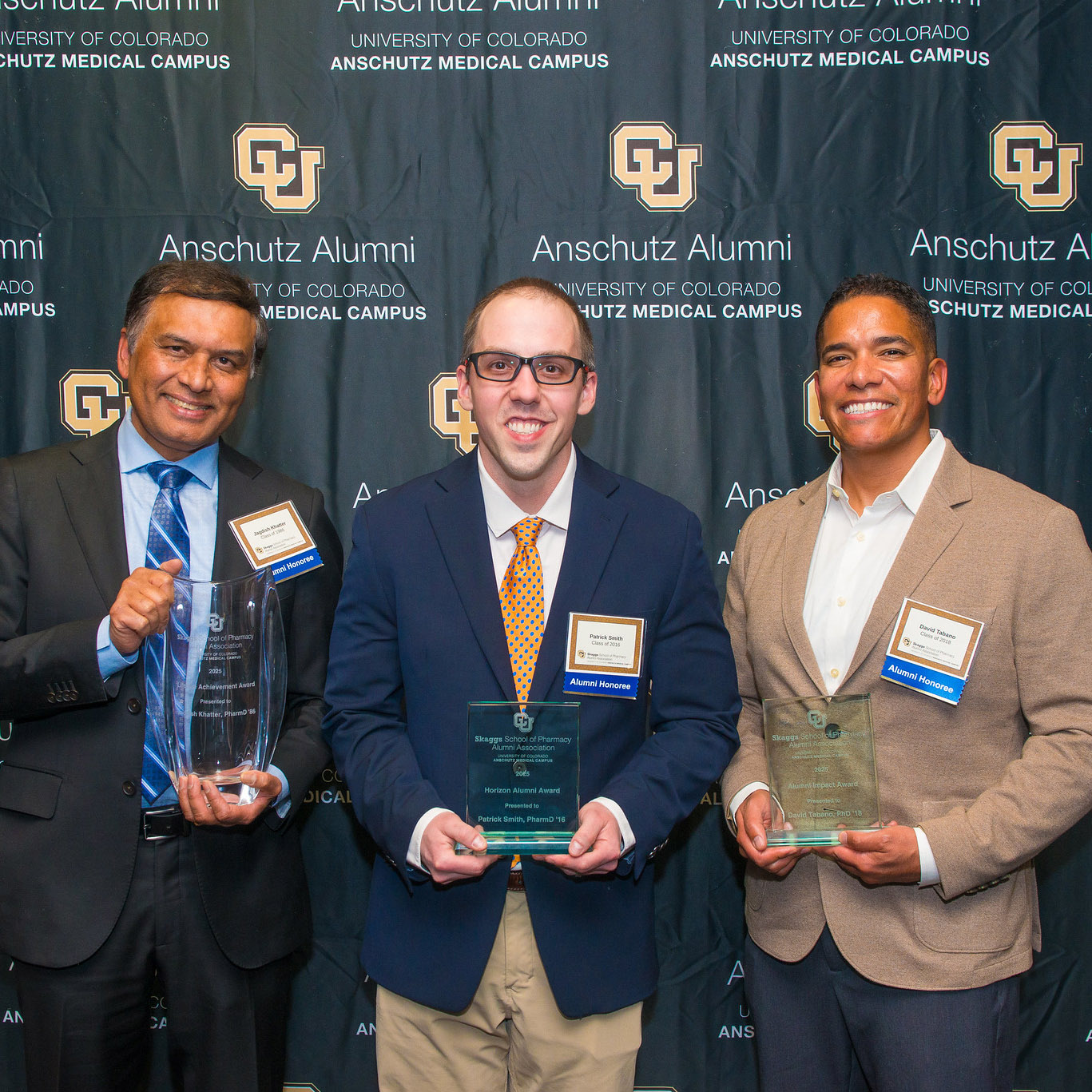 Group of men holding their alumni awards