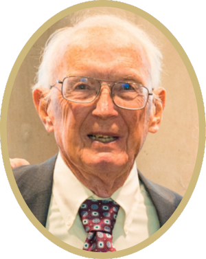 man with glasses in suit and tie smiling for camera