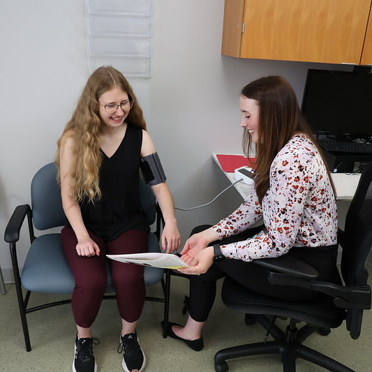 Female pharmacist taking blood pressure 