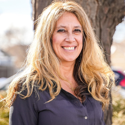Woman with blonde hair and a dark blue button up shirt