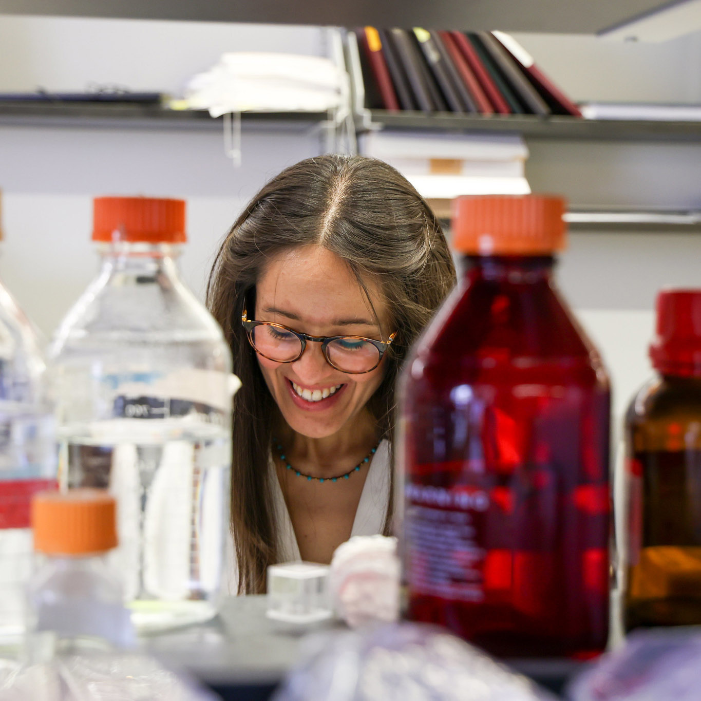 PhD student to looking through bottles in a lab