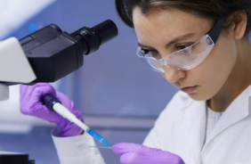 Woman pipetting with a microscope