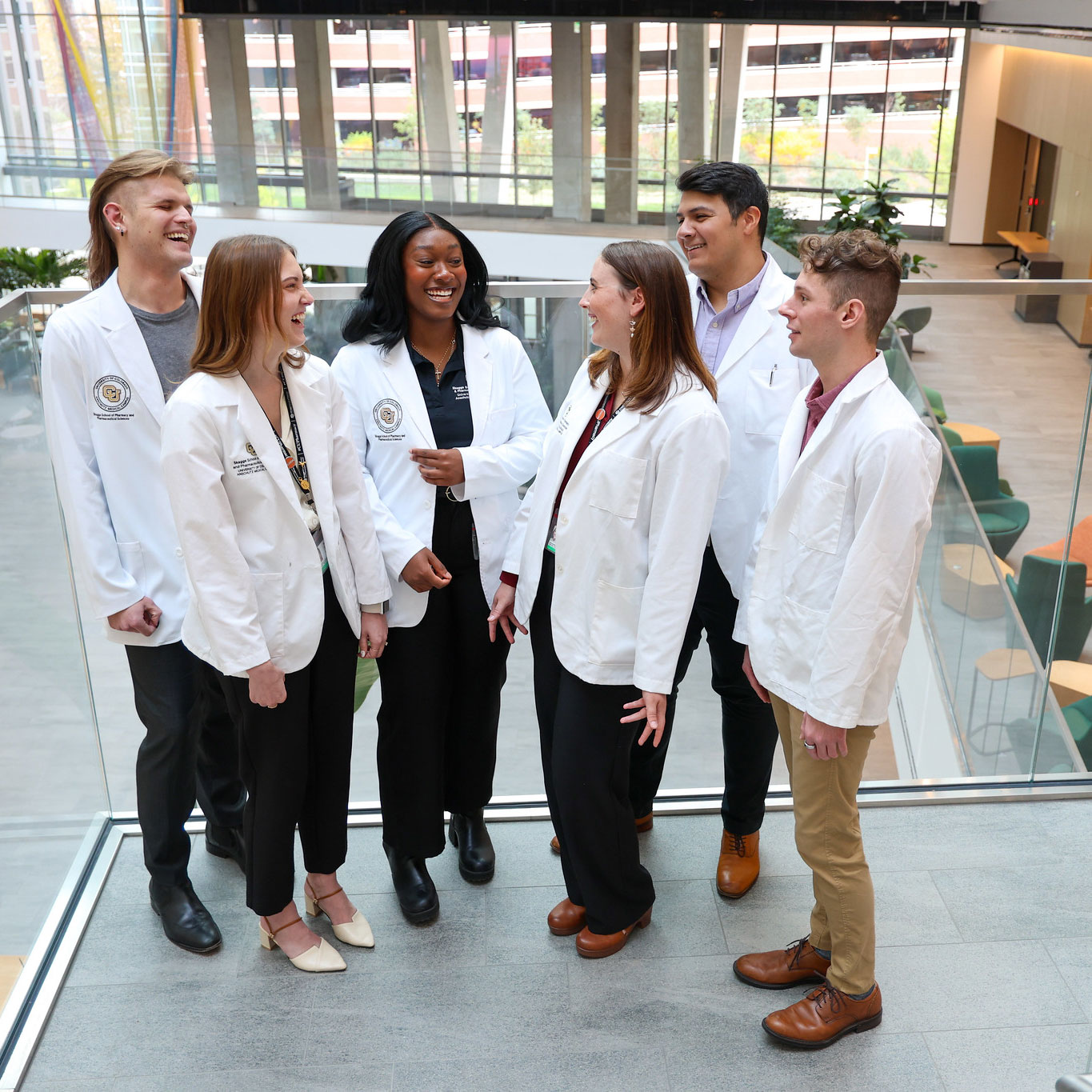Group of students in white coats chatting on the stairs