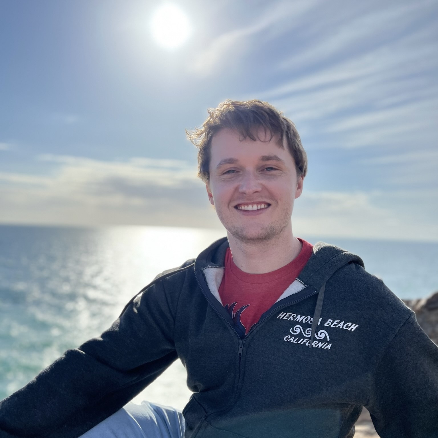 Man with red shirt and short hair at the beach