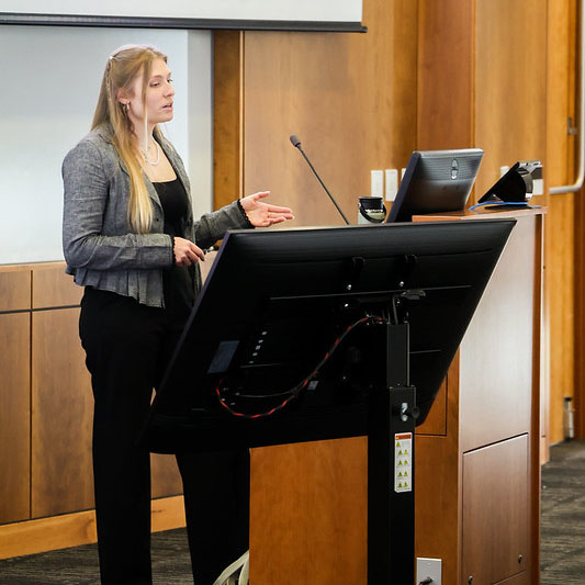 Female student presenting in front of a podium