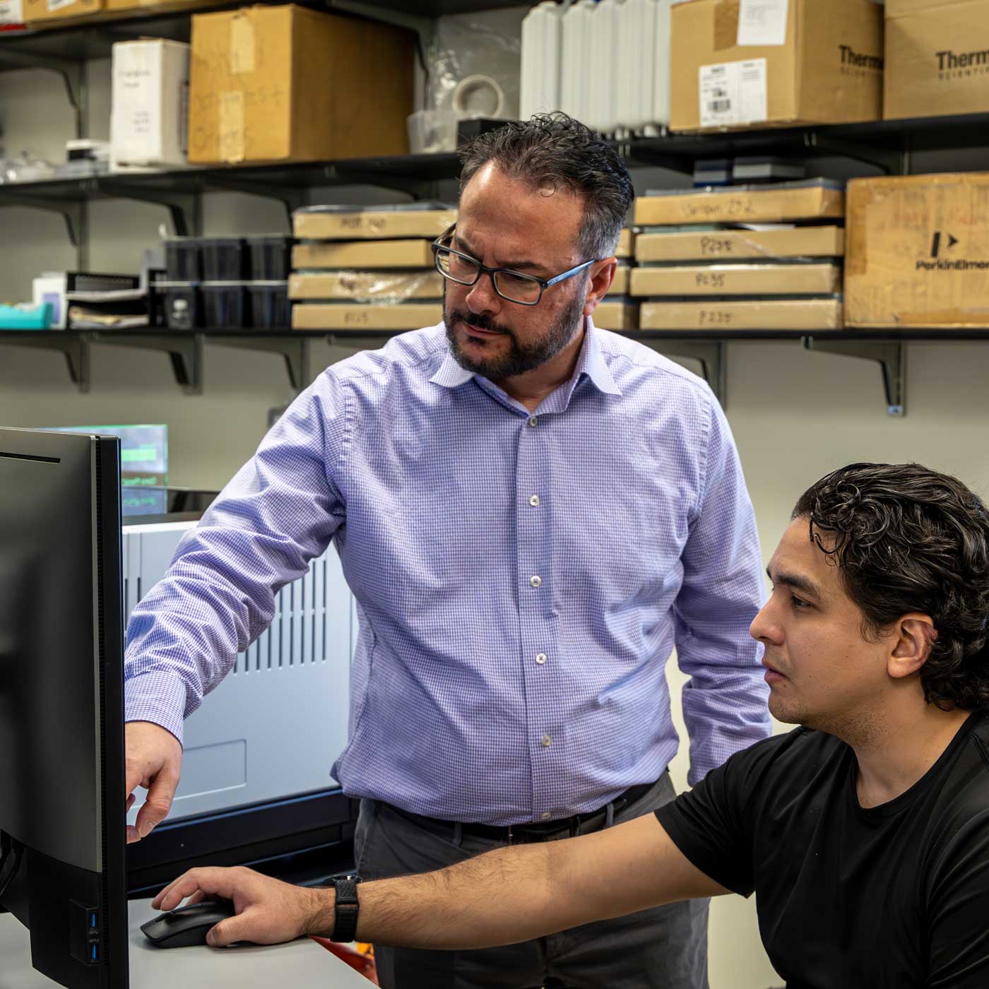 2 men pointing and looking at the computer